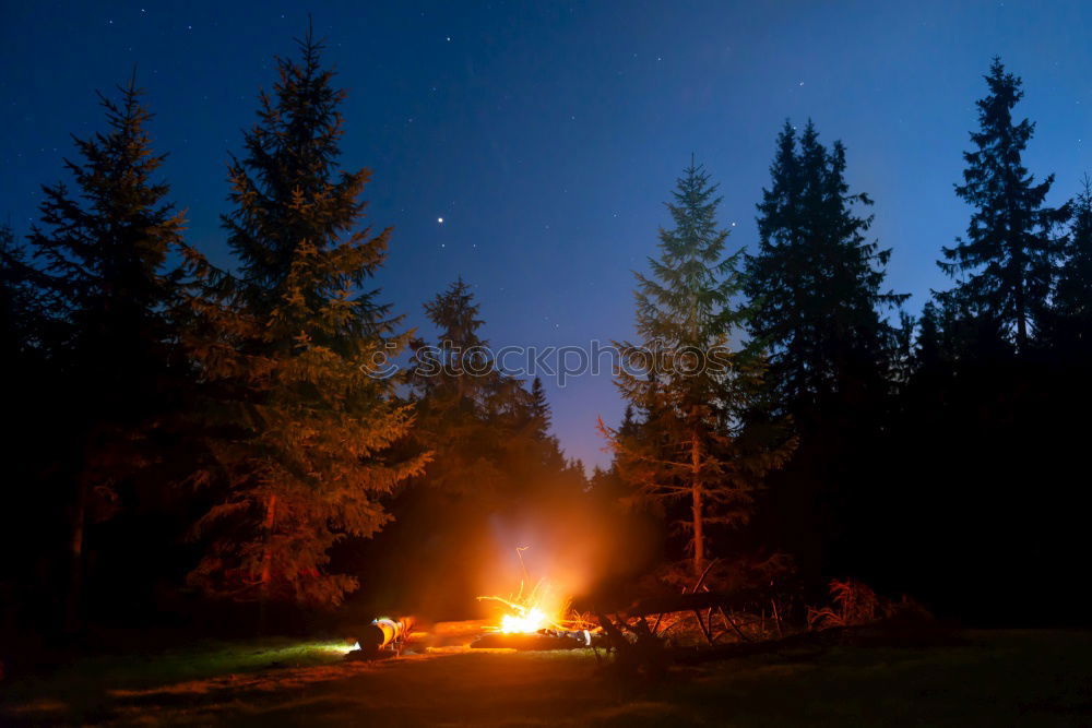 Similar – Man lights a fire in the fireplace in nature at night