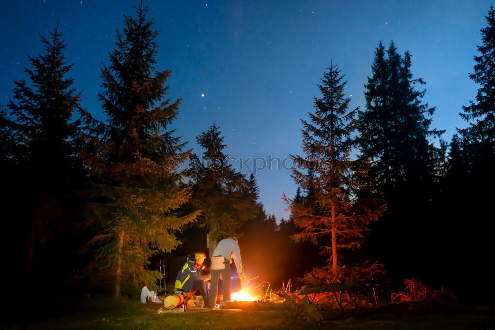 Similar – Man lights a fire in the fireplace in nature at night