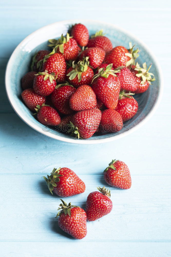 Strawberries in a bowl on an old wooden table