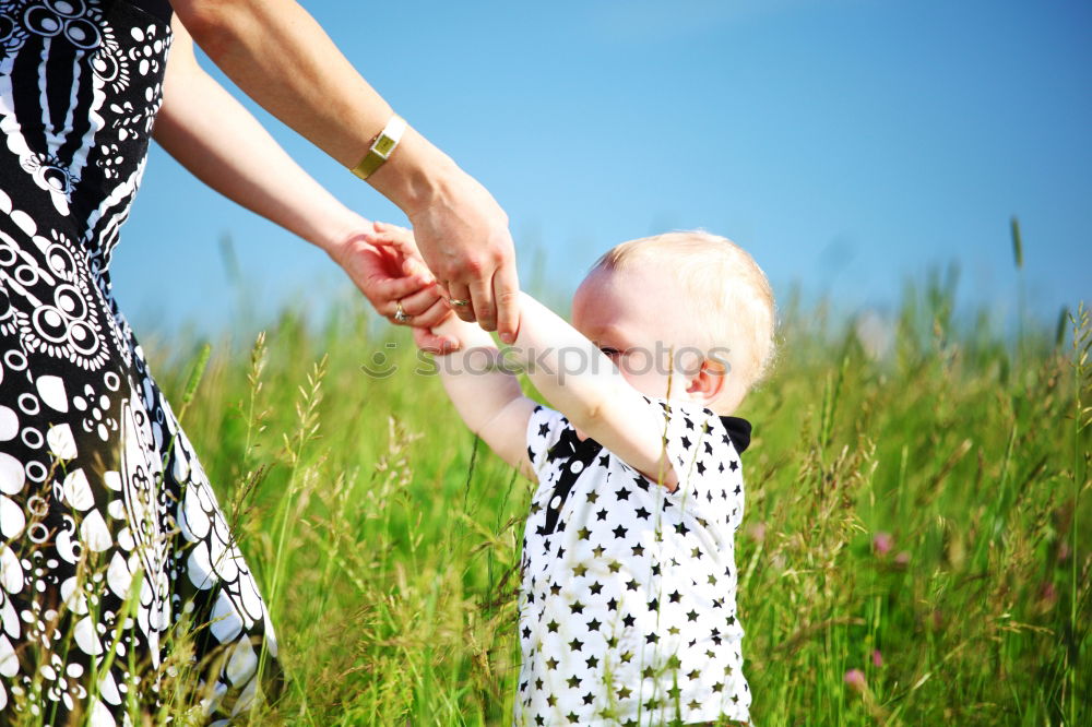 Similar – Baby girl holding finger of senior man hand