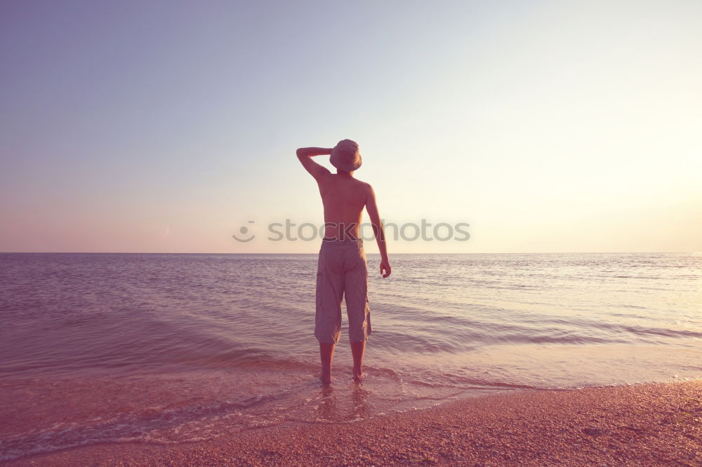 Similar – young nude girl with a hat walks on an empty beach near the sea surf against the blue sky with clouds in summer