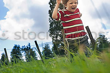 Similar – Little girl walking in nature field wearing beautiful dress