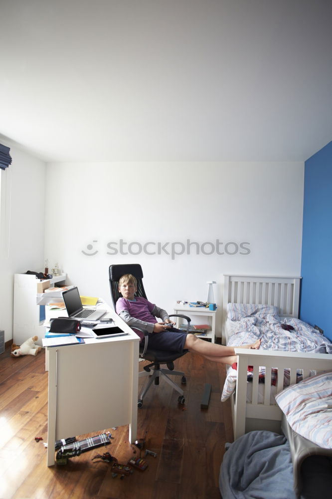 Similar – Young, tall, slim student sits on a chair at her desk and takes a short break