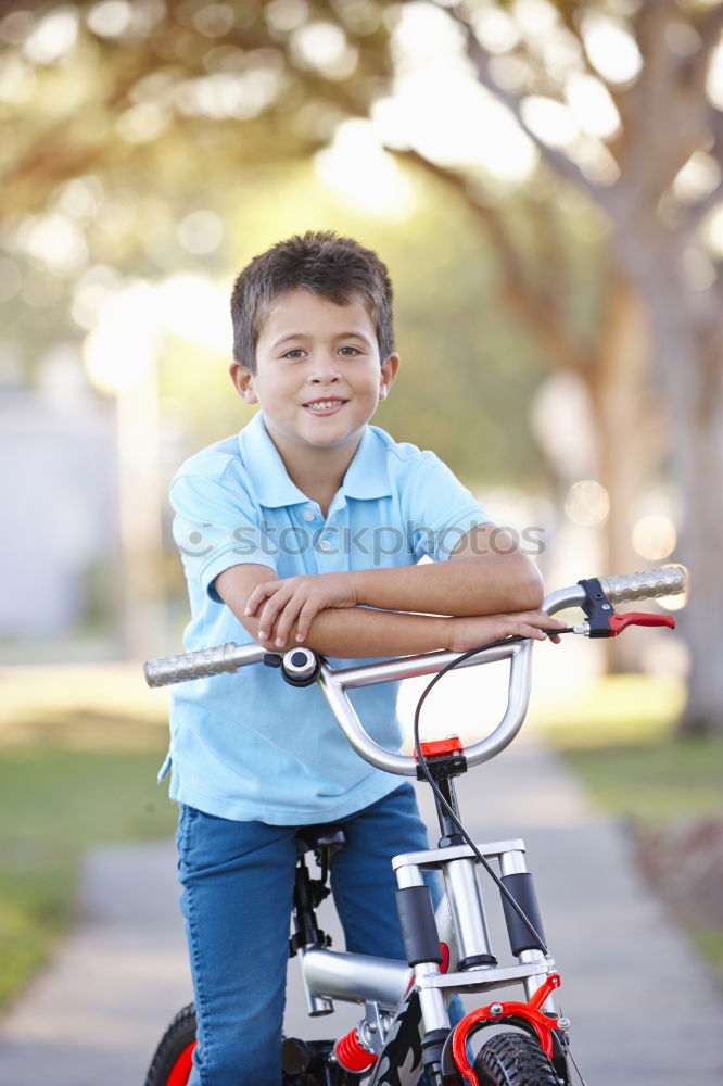 Similar – Image, Stock Photo Litle boy with a bike on a wooden door background