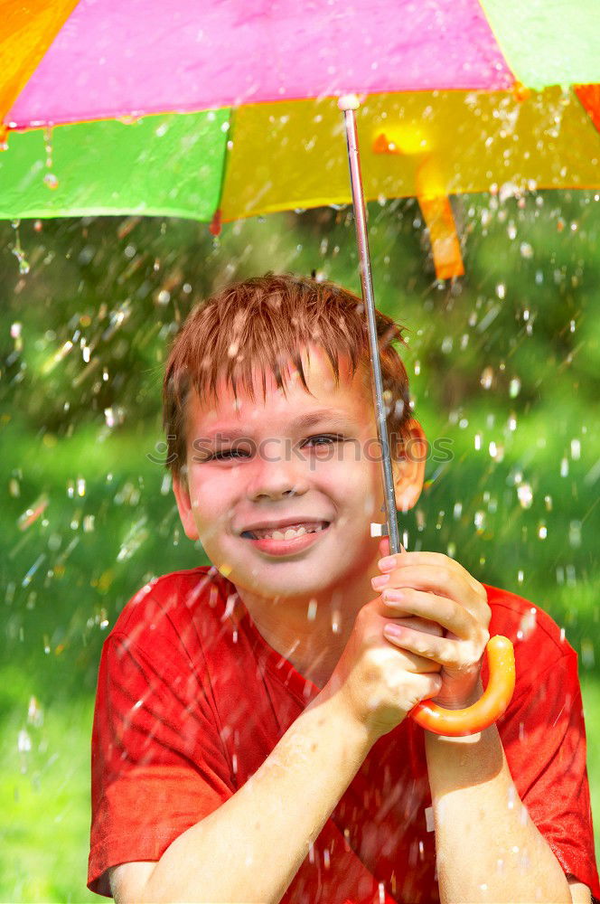 Similar – Image, Stock Photo Child in a raincoat with umbrella crouched down playing and laughing in a puddle