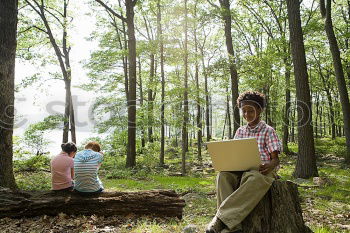 Similar – A man working with his laptop in a forest on the fresh air sitting on a trunk.