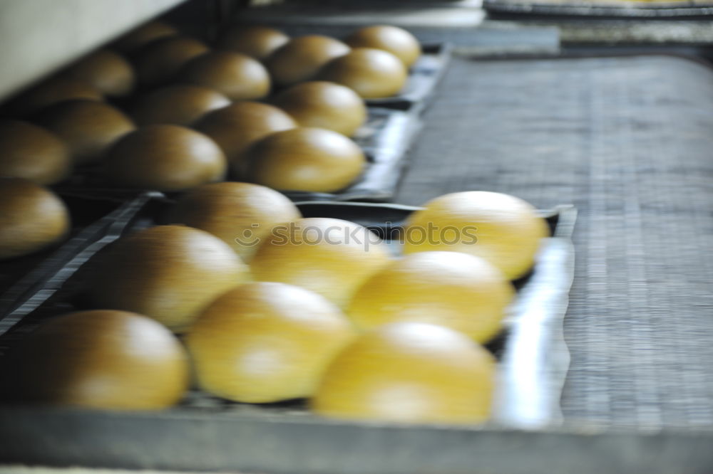 Similar – Fresh loaves of bread on tray racks. Bread bun on bakery shelves