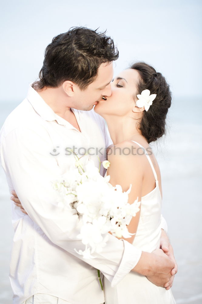 Tender kissing bridal couple in sunlight