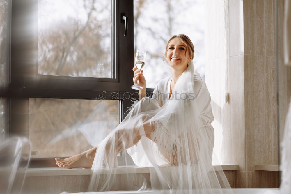 Similar – Young woman sitting on windowsill in sunlit kitchen smiling at camera