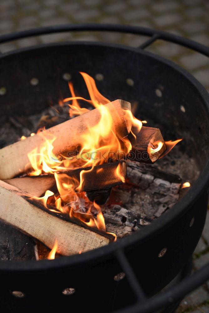 Similar – Ein großer Kochtopf hängt über offenem Feuer einer Feuerschale.