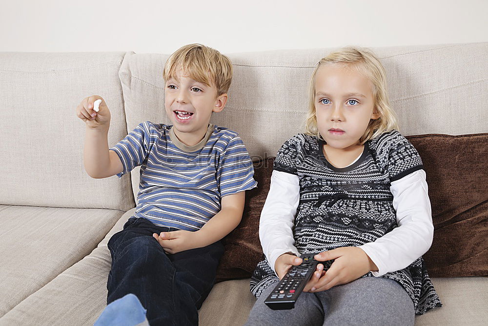 Similar – Image, Stock Photo Kids playing video game sitting on sofa at home