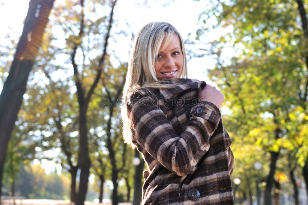 Similar – Young blonde woman sitting on a bench in the street