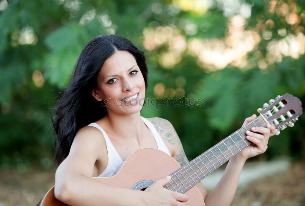 Schöne Frau, die Gitarre spielt.