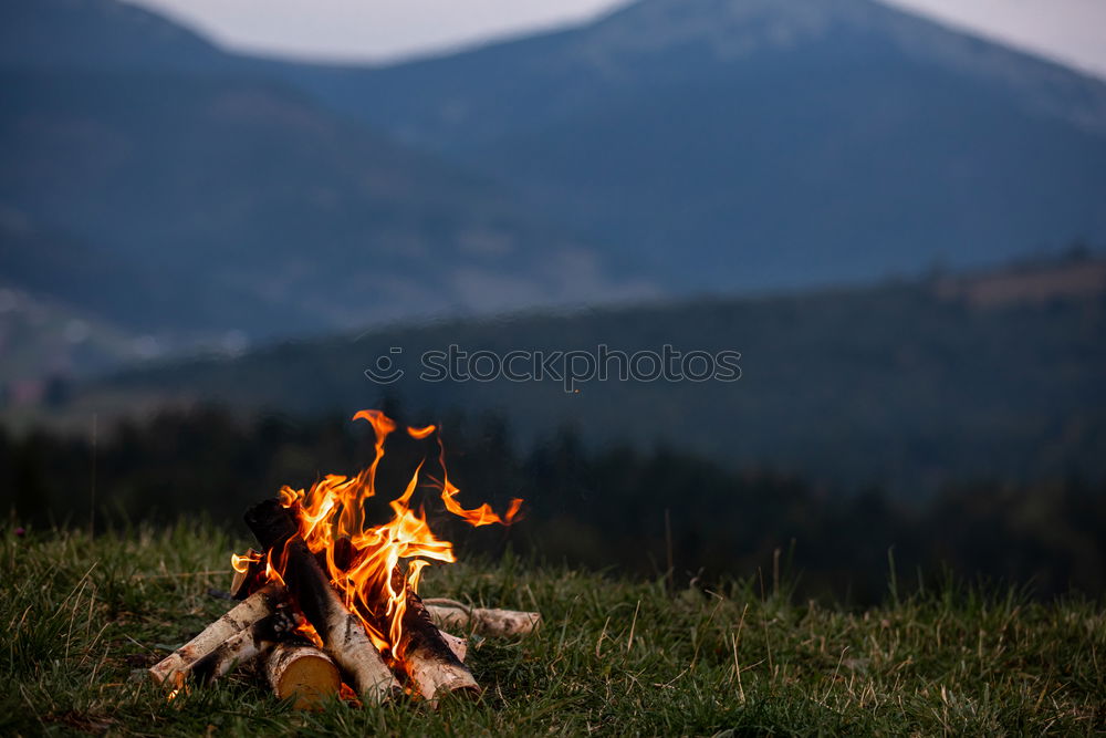 Similar – Man lights a fire in the fireplace in nature at night