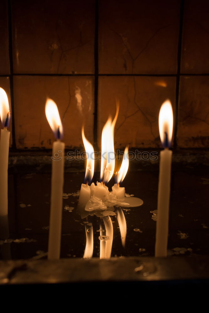 Image, Stock Photo many church candles with varying degrees of burn stuck in the sand in the dark. selective focus. dripping wax from one candle.