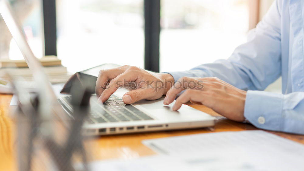 Similar – Young man works on a laptop in the start-up and listens to music through in-ear headphones