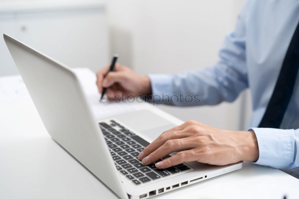 Similar – Young man works on a laptop in the start-up and listens to music through in-ear headphones