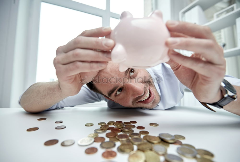 Similar – Unhappy man angry at his piggy bank