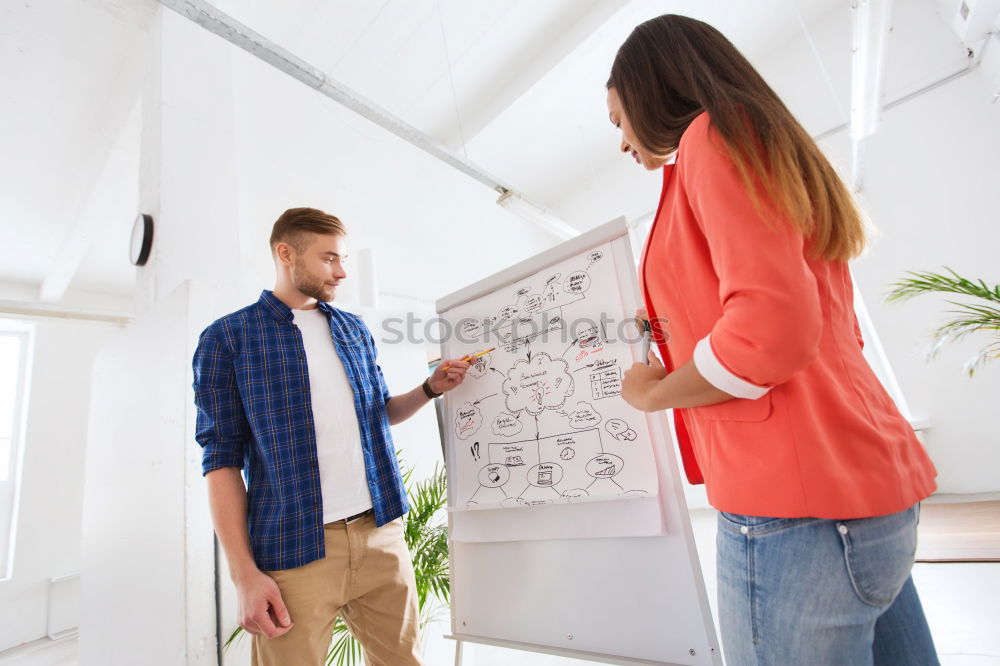 Similar – Businesspeople brainstorming and writing on whiteboard