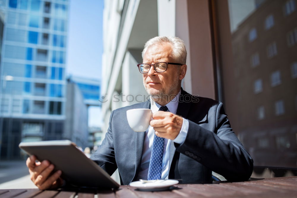 Similar – Image, Stock Photo Handsome businessman with striped tie sits at table with coffee making phone call and using his tablet