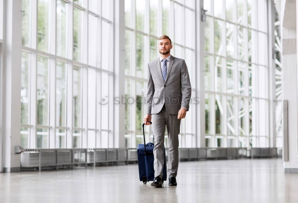 Similar – young businessman walking at the airport using his mobile phone