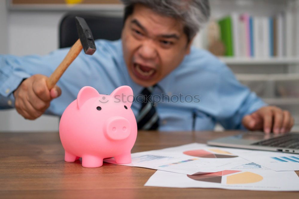 Similar – Unhappy man angry at his piggy bank