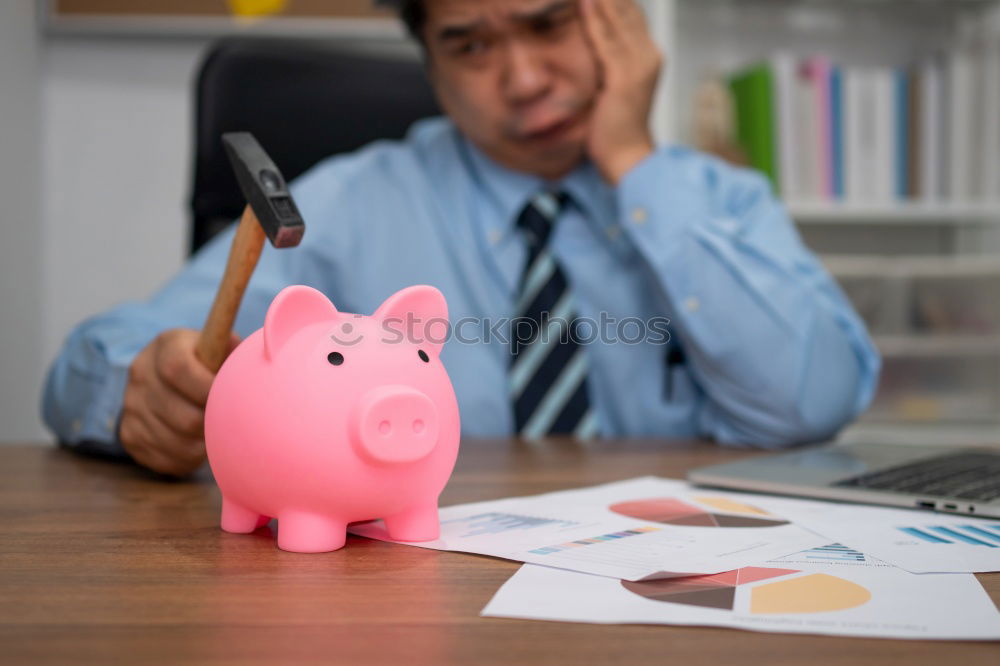 Unhappy man angry at his piggy bank