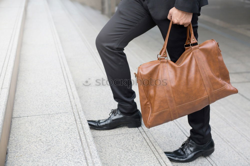 Similar – one person holds a leather travel bag in his hand