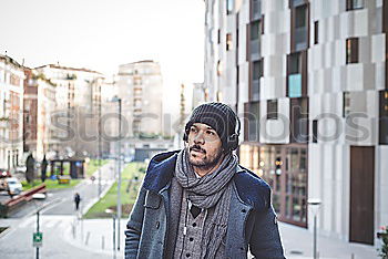 Similar – Young bearded man, model of fashion, in urban background wearing casual clothes while leaning on a wall and looking aside