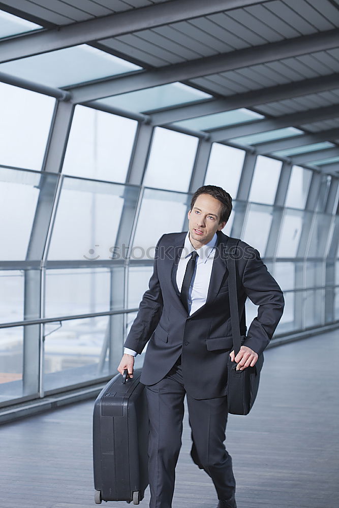 Similar – young businessman walking at the airport using his mobile phone