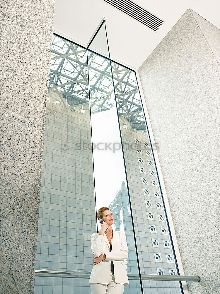 Similar – Woman with umbrella in front of a green wall, in the background skyscrapers