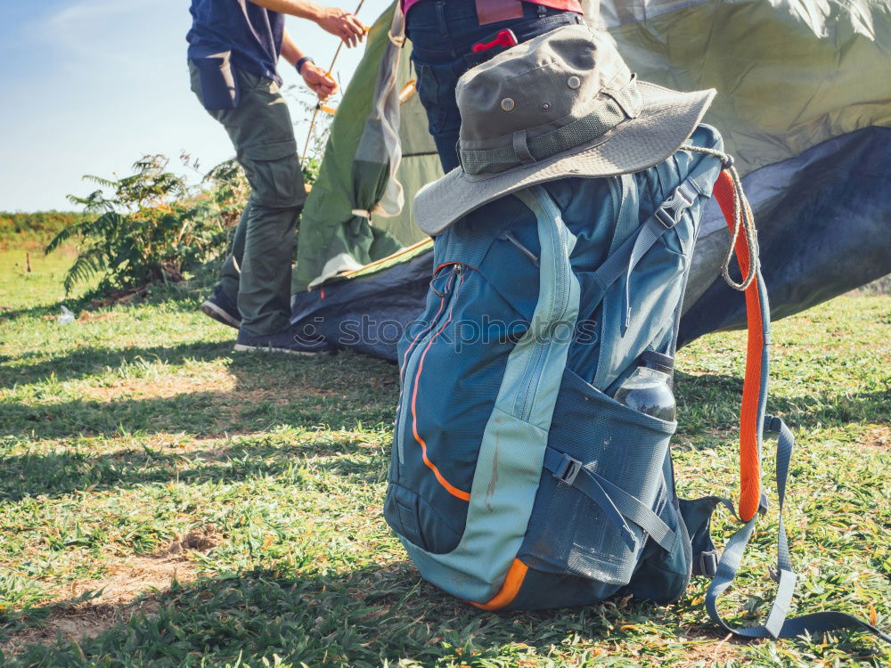 Hiker closing his partner’s backpack