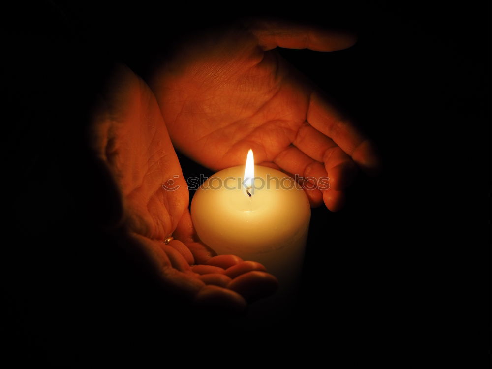 a candle shines in the darkness and gives warmth