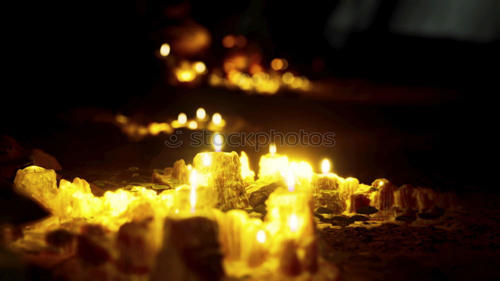 Similar – Image, Stock Photo many church candles with varying degrees of burn stuck in the sand in the dark. selective focus. dripping wax from one candle.