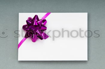 Packed gift with a red ribbon on a white plate