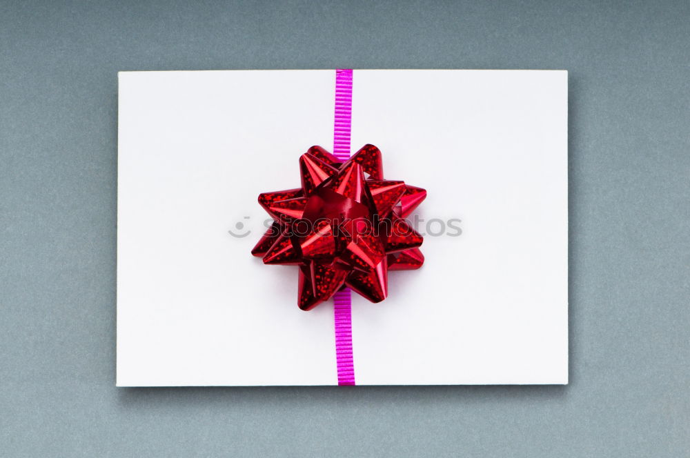 Similar – Packed gift with a red ribbon on a white plate