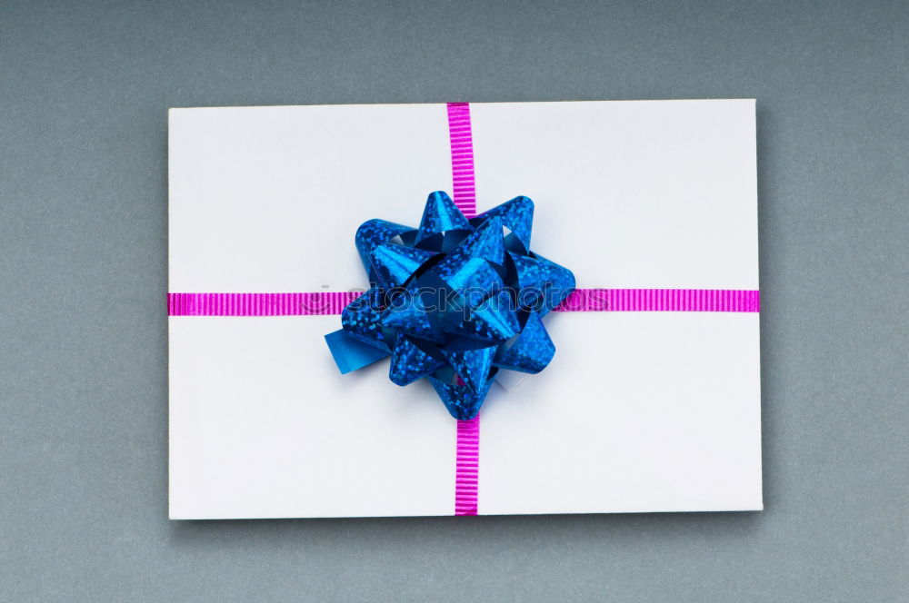 Similar – Packed gift with a red ribbon on a white plate