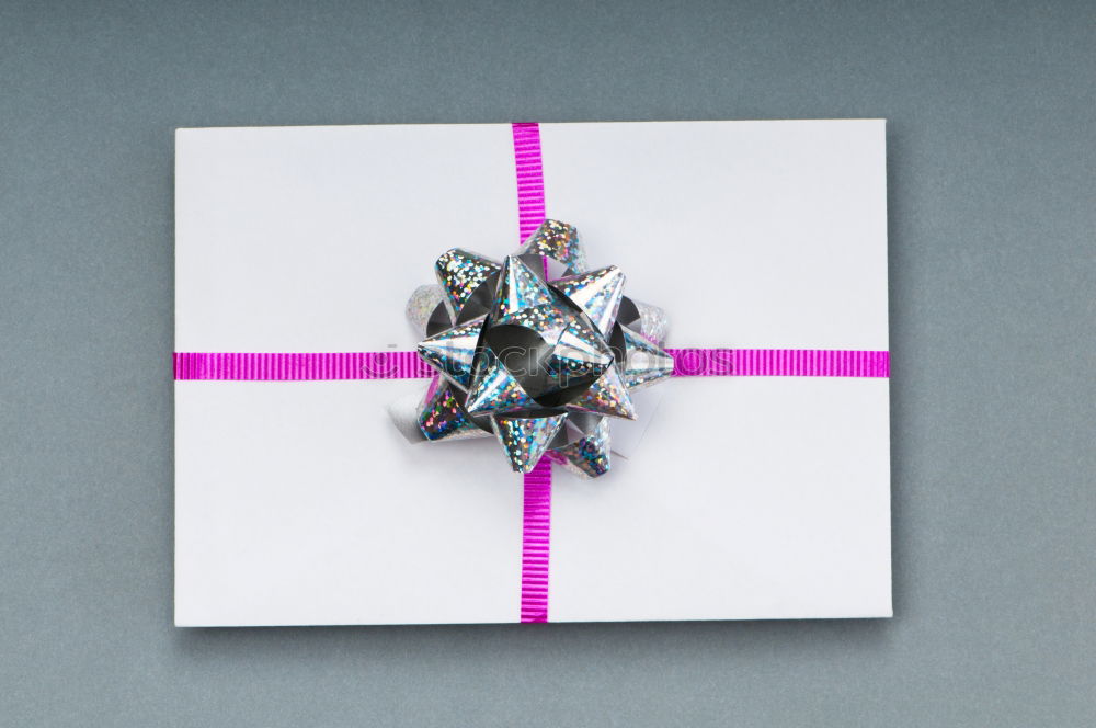 Similar – Packed gift with a red ribbon on a white plate