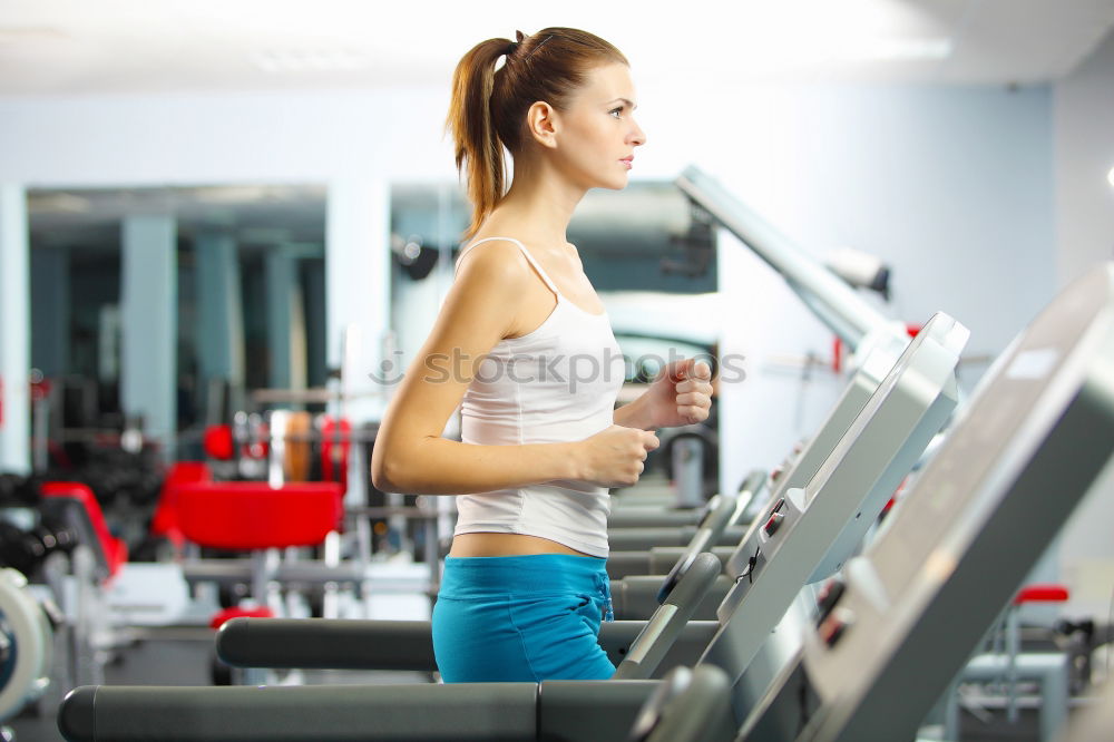 Similar – Woman drinking water while training on treadmill