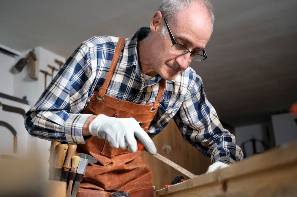 Similar – Professional carpenter cutting wooden board at his workshop