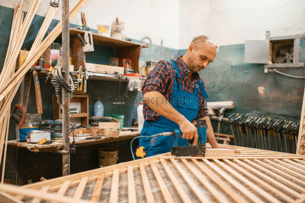 Similar – Professional carpenter cutting wooden board at his workshop