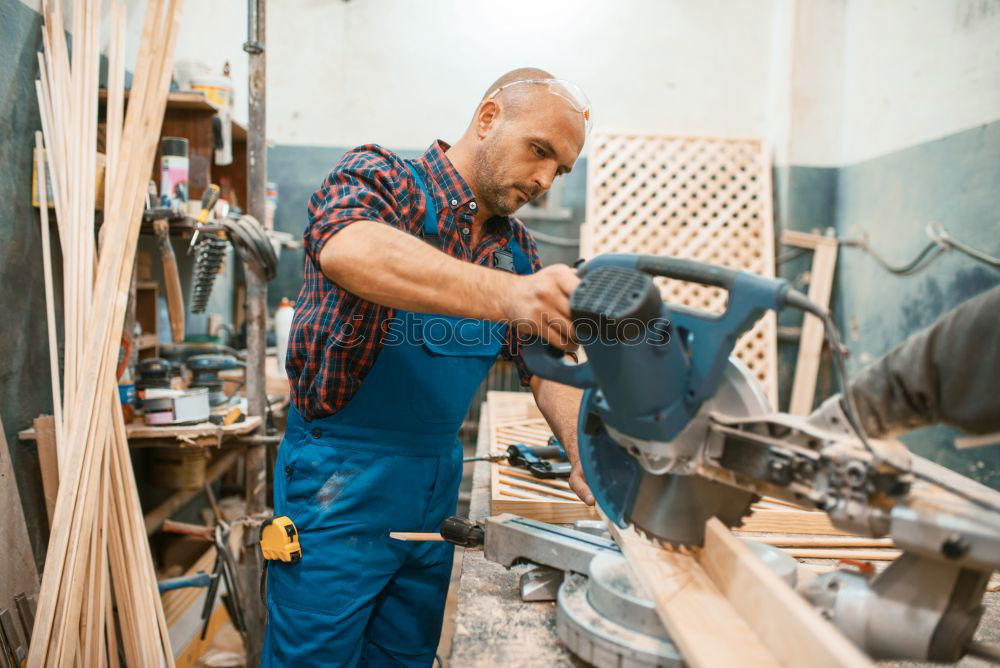 Similar – Carpenter cutting wooden board