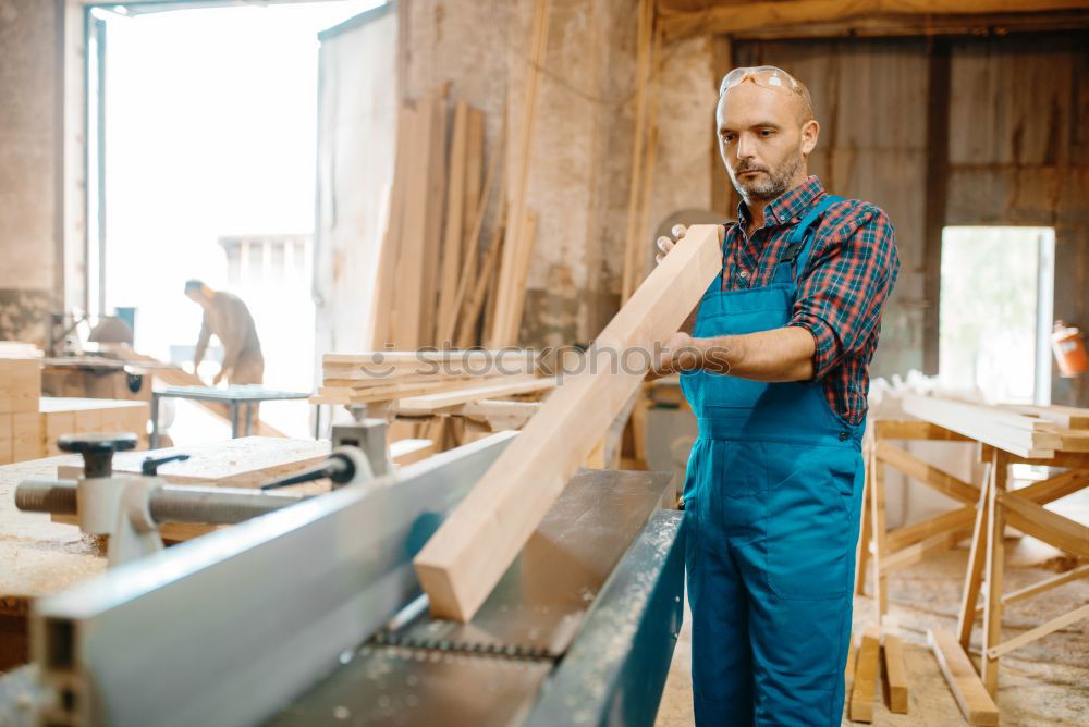 Similar – Professional carpenter cutting wooden board at his workshop