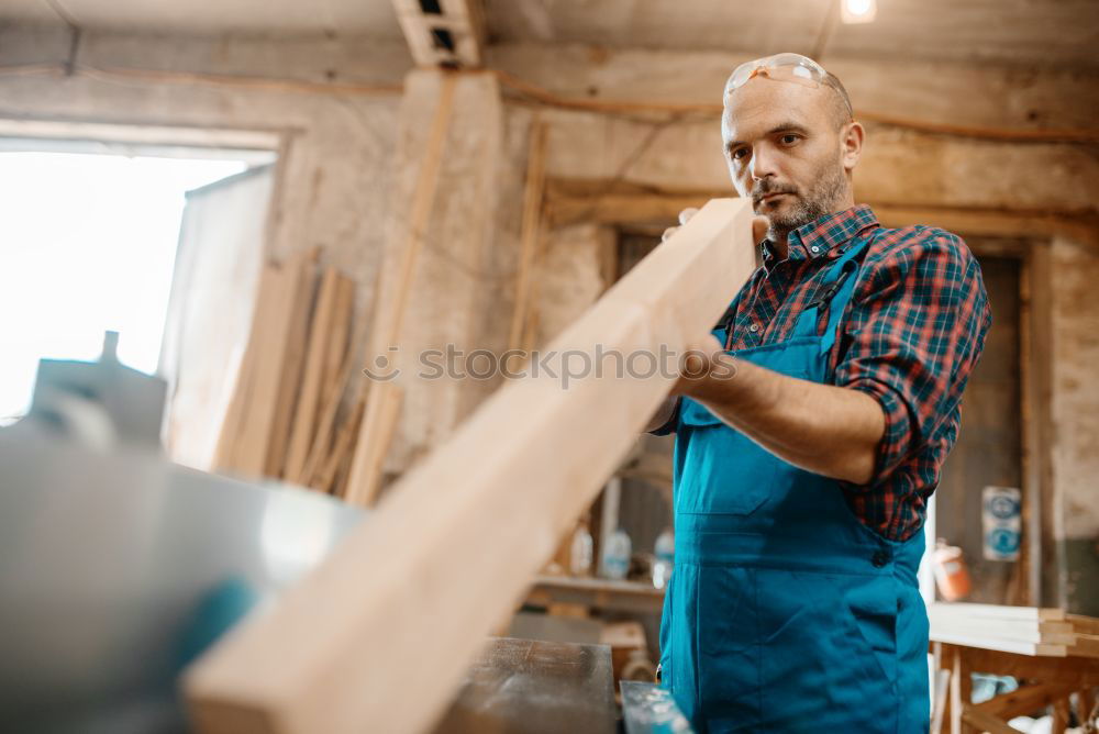 Similar – Professional carpenter cutting wooden board at his workshop