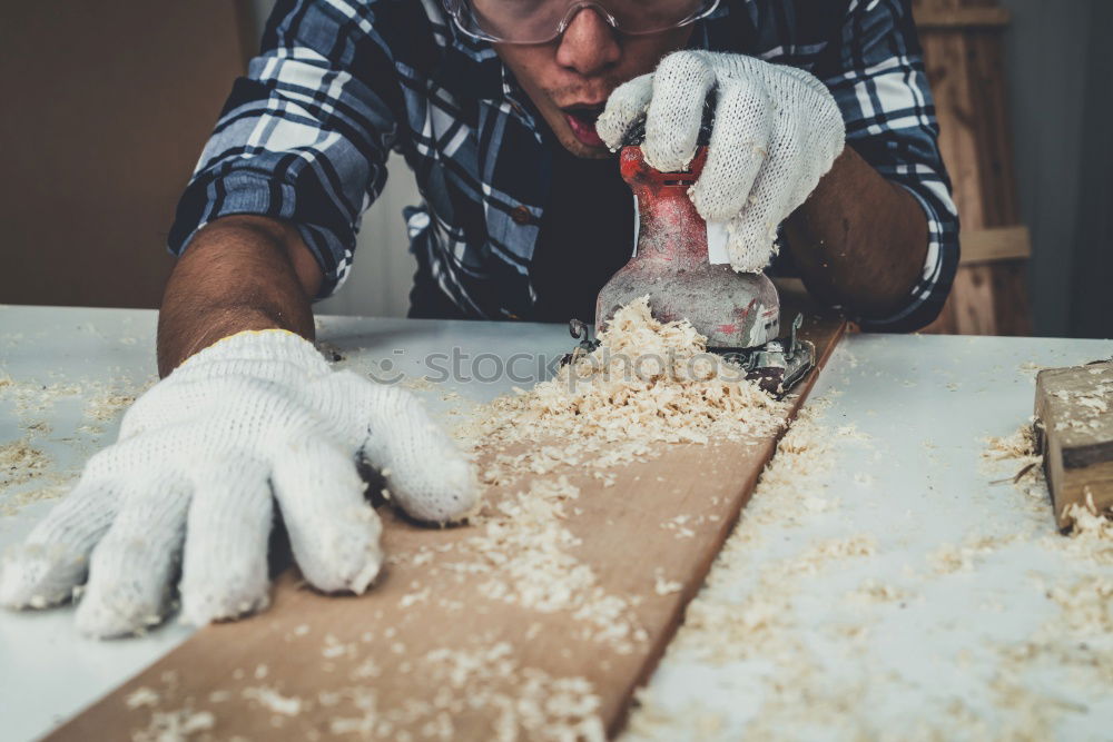 Similar – Carpenter cutting wooden board