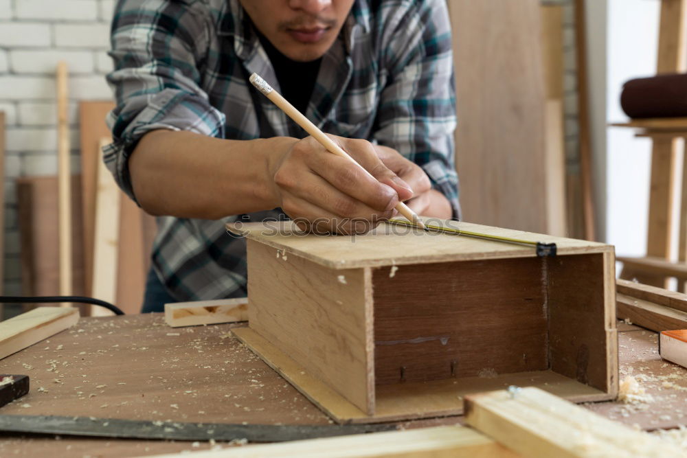 Similar – Carpenter with circular saw cutting a wooden plank