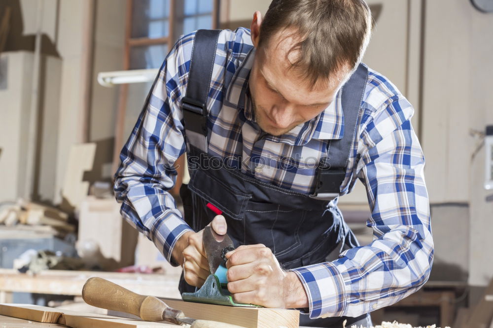 Similar – Carpenter cutting wooden board