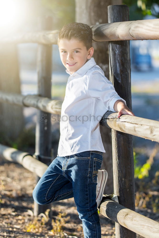 Similar – Little boy with a mibile phone with a wooden door background