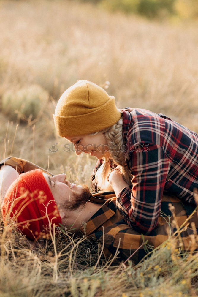 Similar – Young couple under blanket with hot drink kissing outdoors