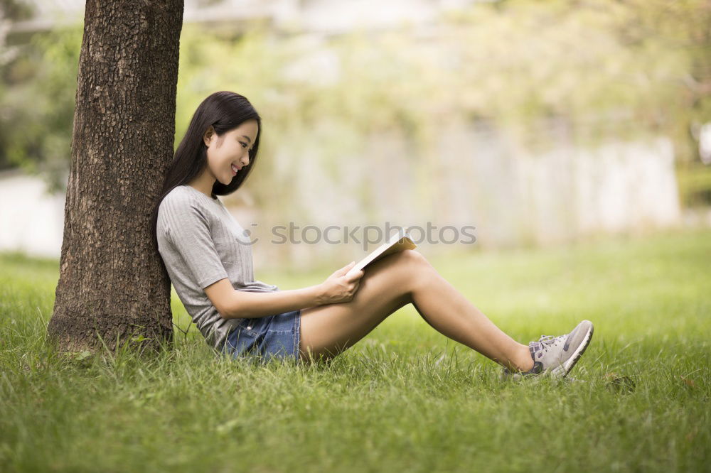 Similar – Woman reading a book outdoors